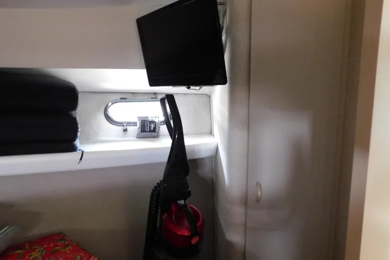 Slide: The Image of Interior of 1992 Silverton 41 Aft Cabin with TV, window, and vacuum cleaner. - 78