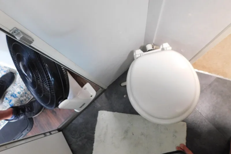 Slide: The Image of Small bathroom with toilet and fan on a 1992 Silverton 41 Aft Cabin boat. - 73