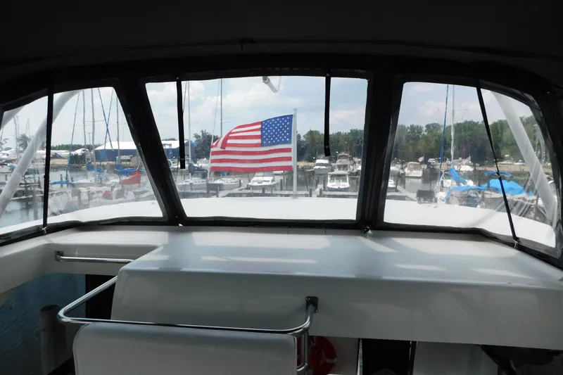 Slide: The Image of 1992 Silverton 41 Aft Cabin yacht with American flag, docked at marina. - 33