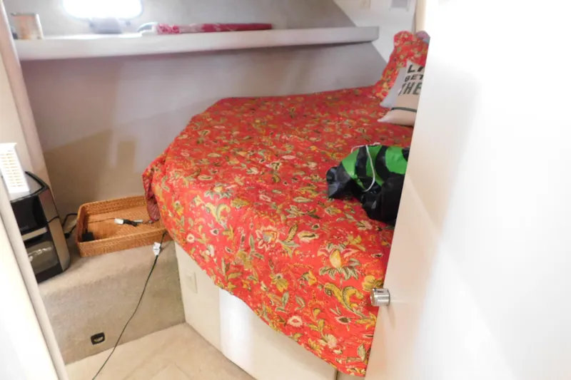 Slide: The Image of 1992 Silverton 41 Aft Cabin interior with vibrant red floral bedding and cozy decor. - 75