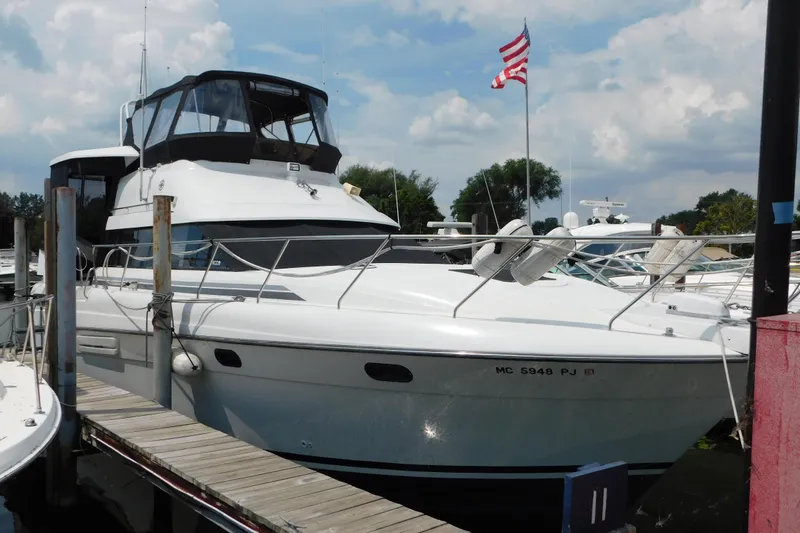 The Image of 1992 Silverton 41 Aft Cabin yacht docked, featuring sleek design and American flag. - 1