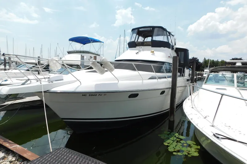 Slide: The Image of 1992 Silverton 41 Aft Cabin yacht docked at marina, surrounded by other boats. - 2