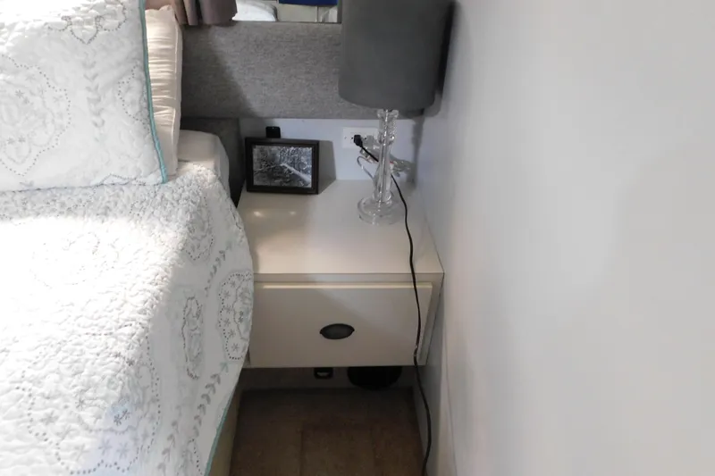 Slide: The Image of Cozy cabin bedroom with white bedding, nightstand, and lamp on Silverton 41 Aft Cabin yacht. - 105