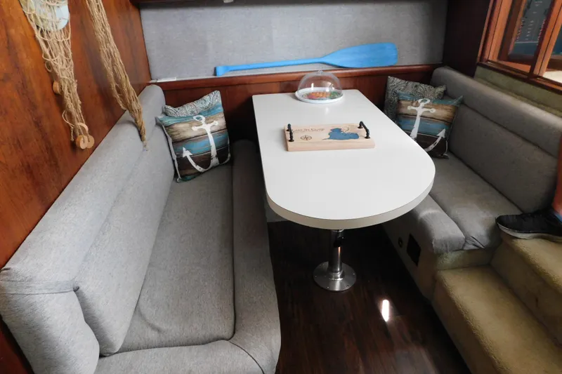 Slide: The Image of Cozy dining area in 1992 Silverton 41 Aft Cabin with nautical decor and cushioned seating. - 68