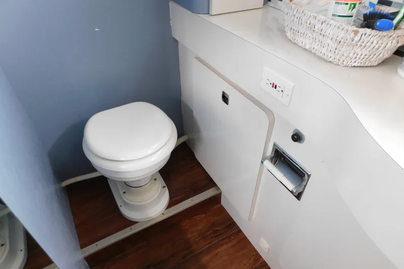 Slide: The Image of 1992 Silverton 41 Aft Cabin bathroom with toilet, storage, and toiletries basket. - 110