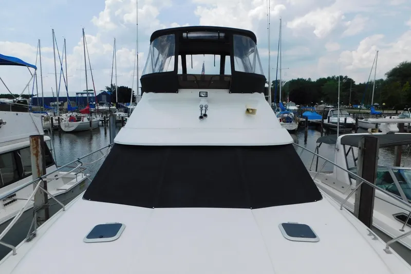 Slide: The Image of 1992 Silverton 41 Aft Cabin yacht docked at marina, surrounded by sailboats. - 17