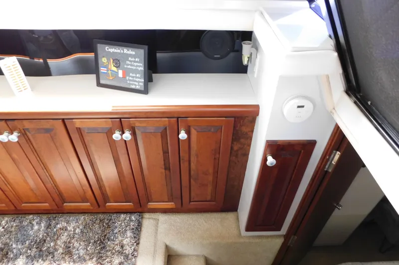 Slide: The Image of Interior of 1992 Silverton 41 Aft Cabin with wooden cabinets and decorative sign. - 44