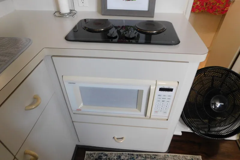 Slide: The Image of Compact kitchen area in a 1992 Silverton 41 Aft Cabin with stove and microwave. - 64
