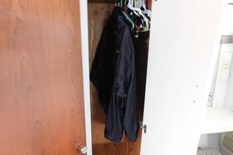 Slide: The Image of Open closet with hanging jackets inside a 1992 Silverton 41 Aft Cabin boat. - 112