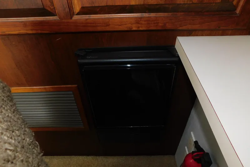 Slide: The Image of 1992 Silverton 41 Aft Cabin interior with fridge, wooden cabinetry, and fire extinguisher. - 84
