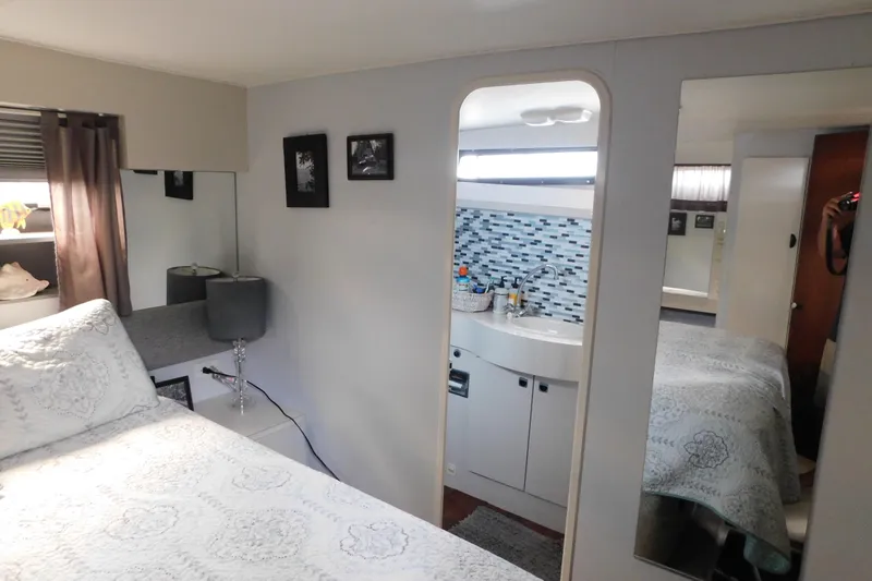 Slide: The Image of Cozy interior of 1992 Silverton 41 Aft Cabin with bed, mirror, and bathroom sink. - 103