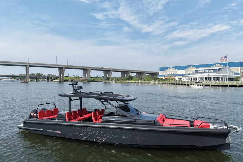 Slide: The Image of 2021 BRABUS 900 Shadow yacht with red seating, docked near a bridge and marina. - 3
