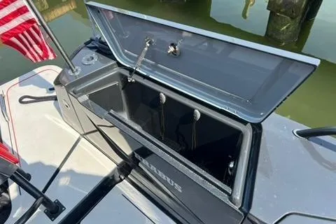 Slide: The Image of 2021 BRABUS 900 Shadow boat storage compartment with open lid, docked near water. - 34