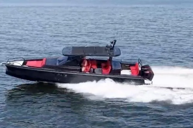 Slide: The Image of 2021 BRABUS 900 Shadow boat cruising on open water, featuring sleek design and red seating. - 2