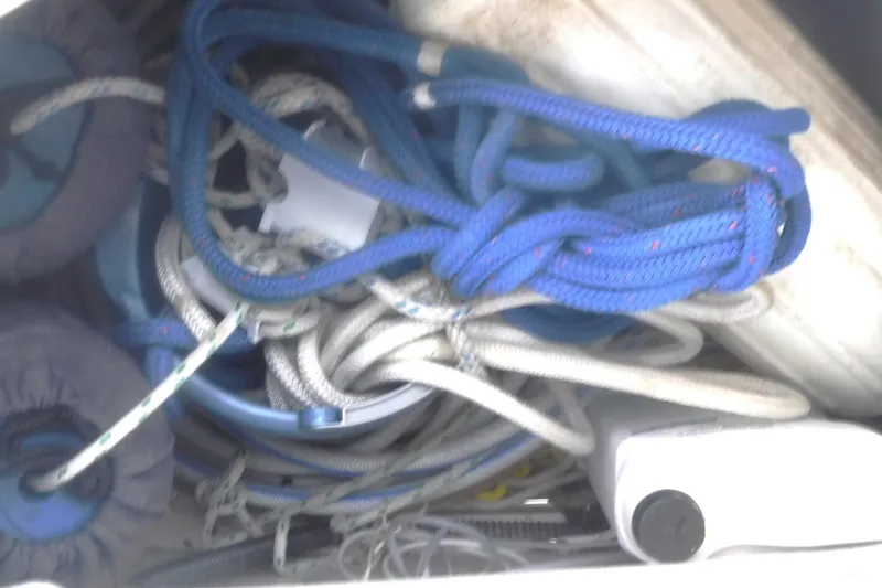 Slide: The Image of Tangled ropes and equipment in a 1998 Catalina 320 sailboat storage compartment. - 16