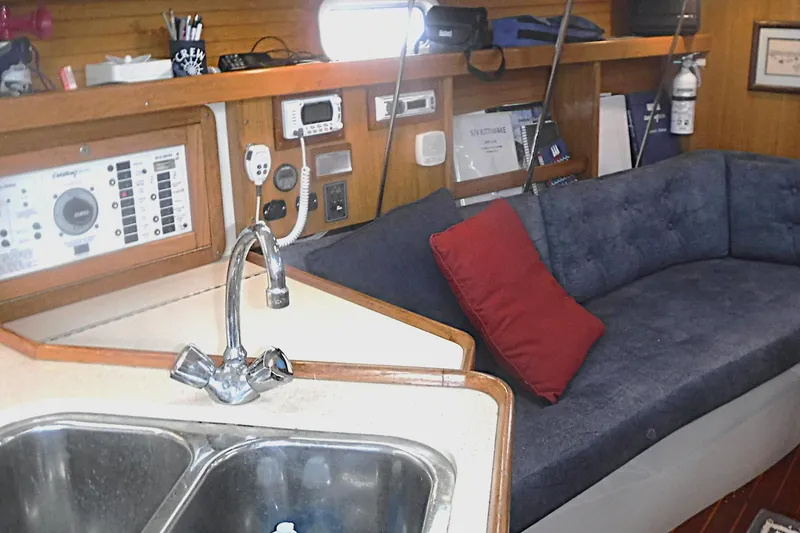 Slide: The Image of Interior of a 1998 Catalina 320 sailboat with a cozy seating area and kitchen sink. - 47