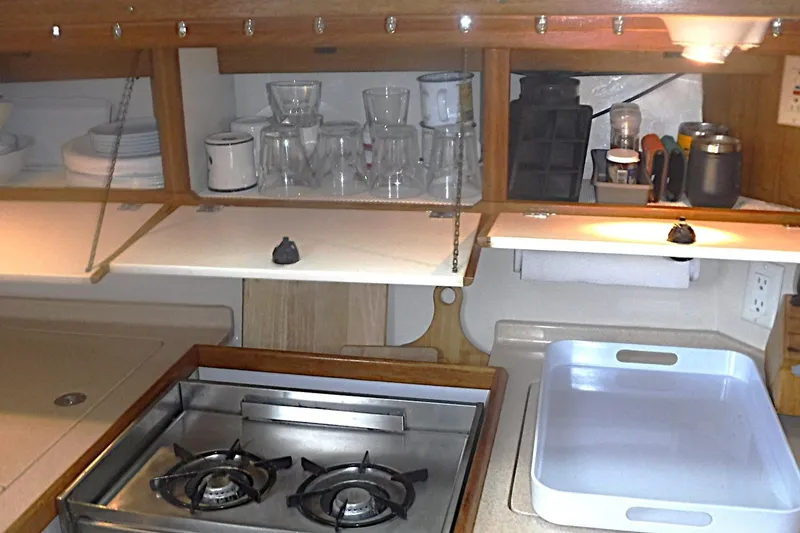 Slide: The Image of Compact kitchen area in a 1998 Catalina 320 sailboat with stove and storage. - 40