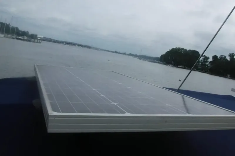 Slide: The Image of Solar panel on a 1998 Catalina 320 sailboat, overlooking a serene waterfront. - 9