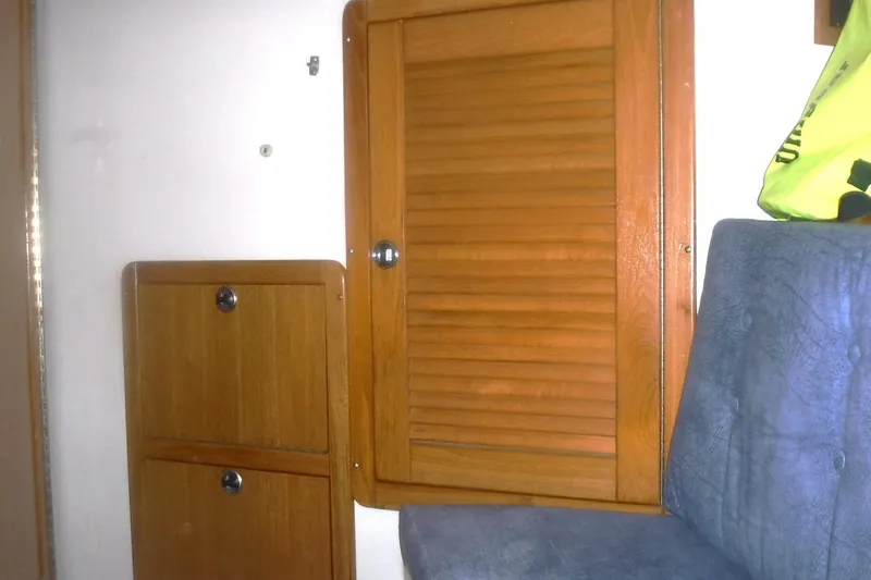 Slide: The Image of Interior of a 1998 Catalina 320 sailboat with wooden cabinets and blue upholstery. - 61