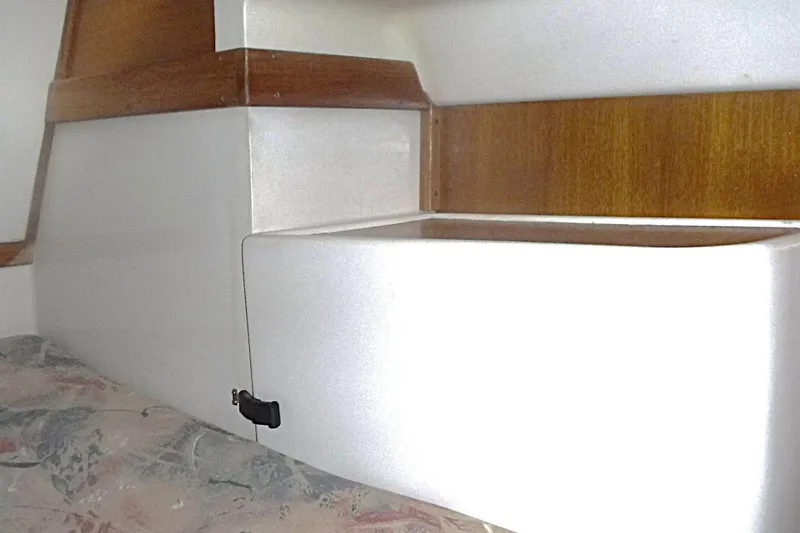 Slide: The Image of Interior cabin detail of a 1998 Catalina 320 sailboat, featuring wood accents and storage. - 58