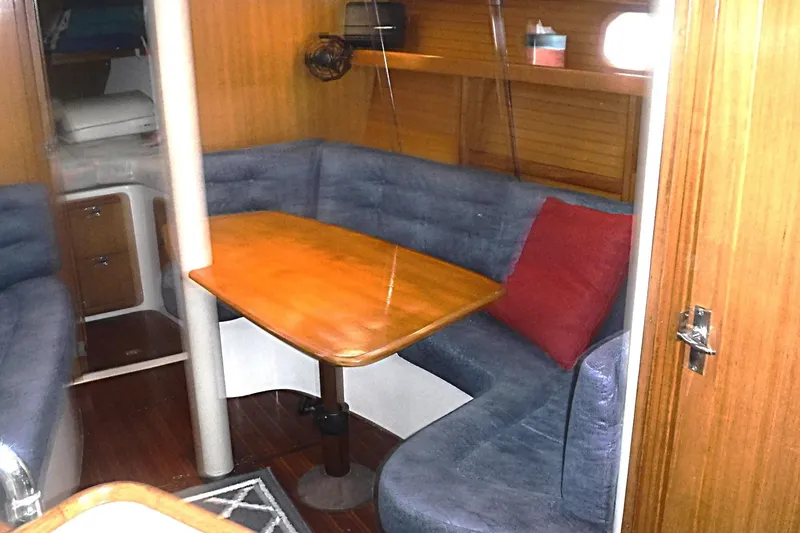 Slide: The Image of Interior of a 1998 Catalina 320 sailboat with cozy seating and wooden table. - 49