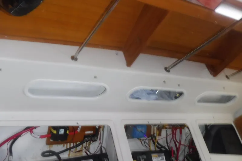 Slide: The Image of Interior view of a 1998 Catalina 320 sailboat, showcasing electrical wiring and wooden cabinetry. - 76
