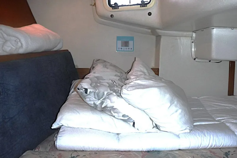 Slide: The Image of Cozy cabin interior of a 1998 Catalina 320 sailboat with bedding and porthole. - 60