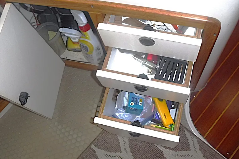 Slide: The Image of Open drawers in a 1998 Catalina 320 boat, revealing cleaning supplies and tools. - 41