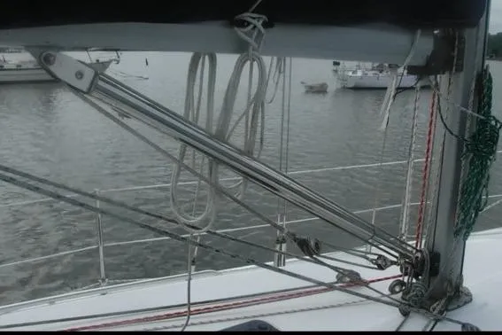 Slide: The Image of 1998 Catalina 320 sailboat deck with rigging and ropes on a calm water background. - 7