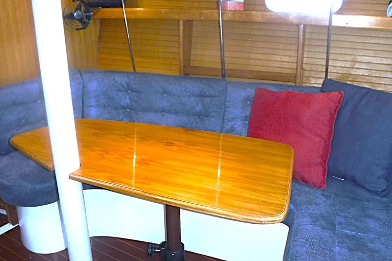 Slide: The Image of Interior of a 1998 Catalina 320 sailboat with a cozy dining area and wooden table. - 50