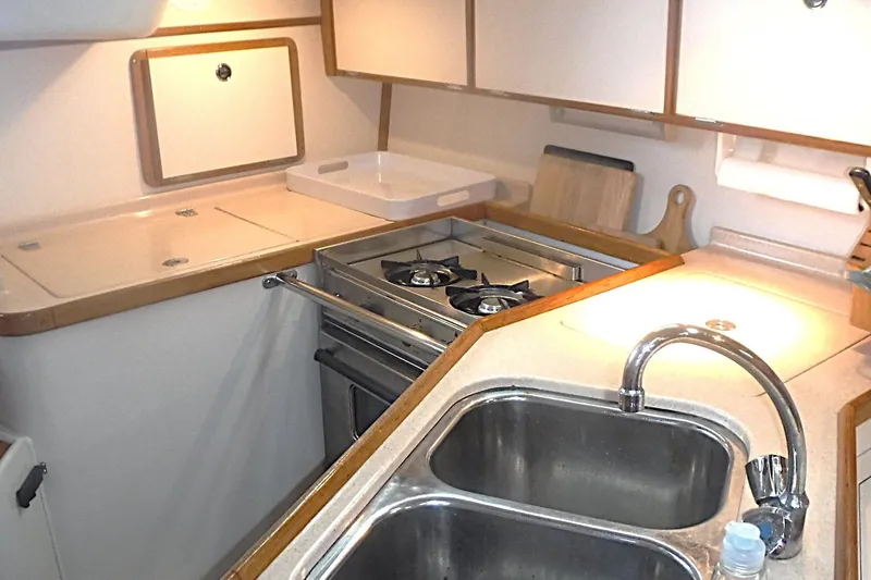 Slide: The Image of Compact kitchen in a 1998 Catalina 320 sailboat with dual sinks and a stove. - 33