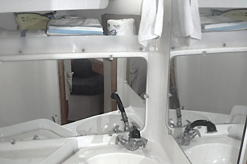Slide: The Image of Interior of 1998 Catalina 320 yacht bathroom with sink, mirror, and storage shelves. - 66