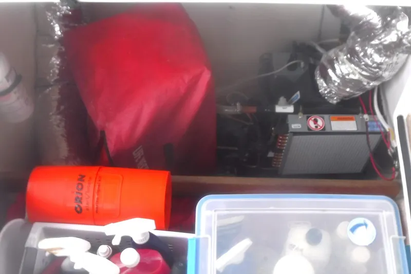 Slide: The Image of Engine compartment of a 1998 Catalina 320 sailboat with equipment and storage items. - 17