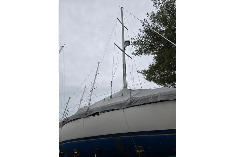 Slide: The Image of Sailboat Catalina 320, 1998 model, covered and docked, with visible mast and rigging. - 3