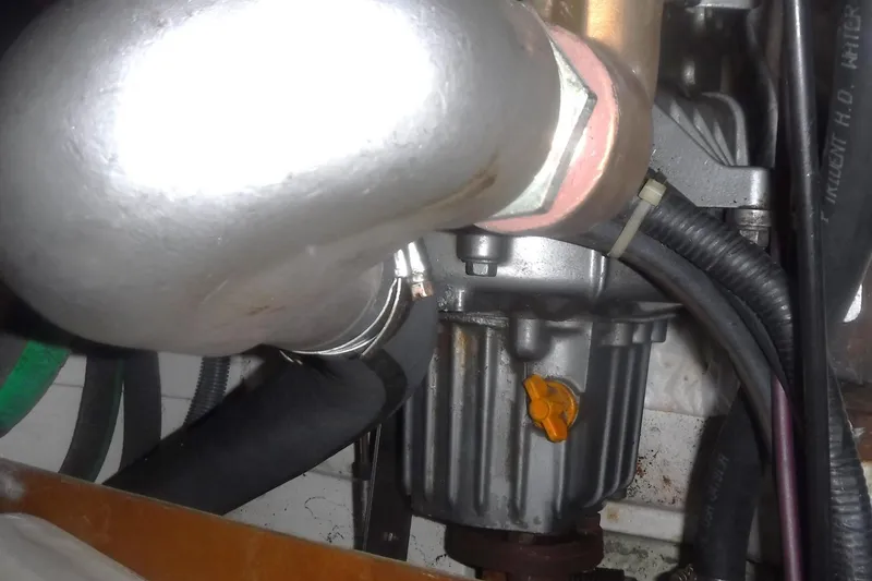 Slide: The Image of Engine compartment of a 1998 Catalina 320 sailboat, showing hoses and mechanical components. - 68