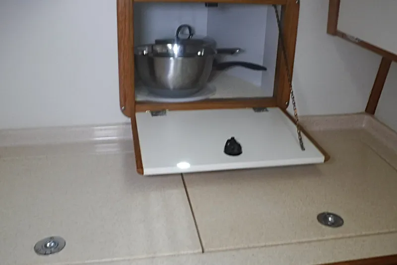 Slide: The Image of Galley area of a 1998 Catalina 320 sailboat with storage and cookware. - 34