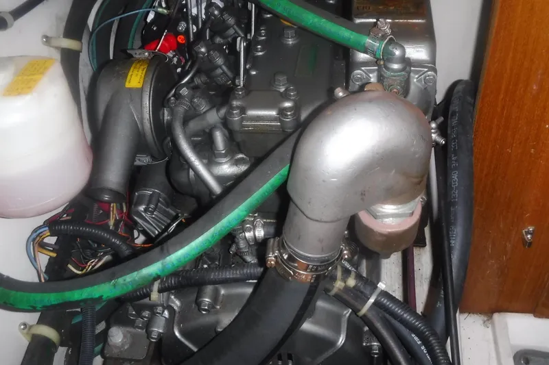 Slide: The Image of Engine compartment of a 1998 Catalina 320 sailboat, featuring hoses and mechanical components. - 70