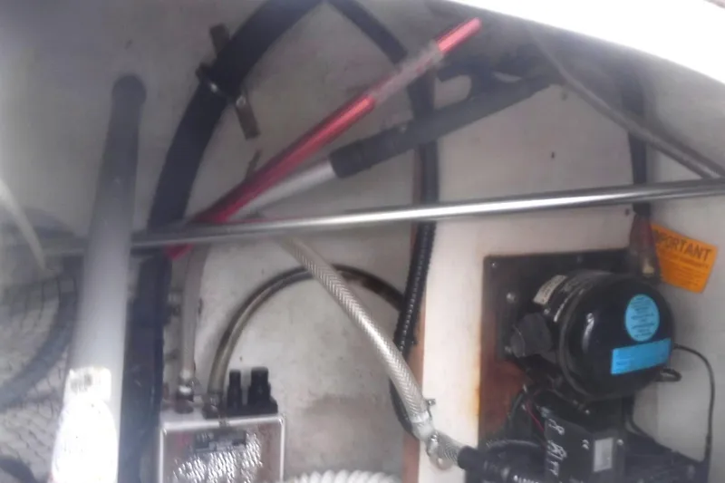 Slide: The Image of Engine compartment of a 1998 Catalina 320 sailboat, showing various mechanical components and hoses. - 13