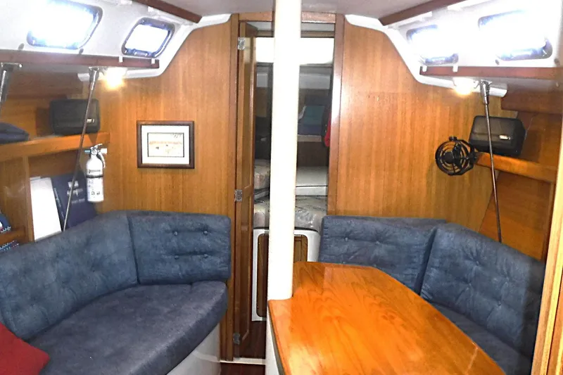 Slide: The Image of Interior of a 1998 Catalina 320 sailboat with cozy seating and wooden table. - 48