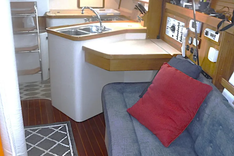 Slide: The Image of Interior of a 1998 Catalina 320 sailboat with kitchen and seating area. - 52