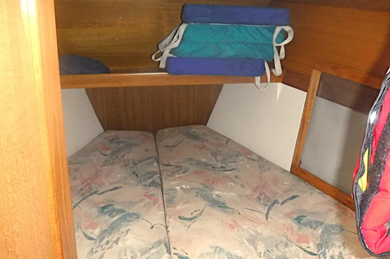 Slide: The Image of Cozy cabin interior of 1998 Catalina 320 sailboat with patterned cushions and storage space. - 54