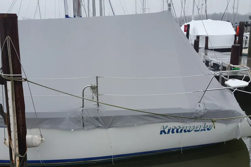 Slide: The Image of 1998 Catalina 320 sailboat named "Kittiwake" covered at a marina dock. - 5