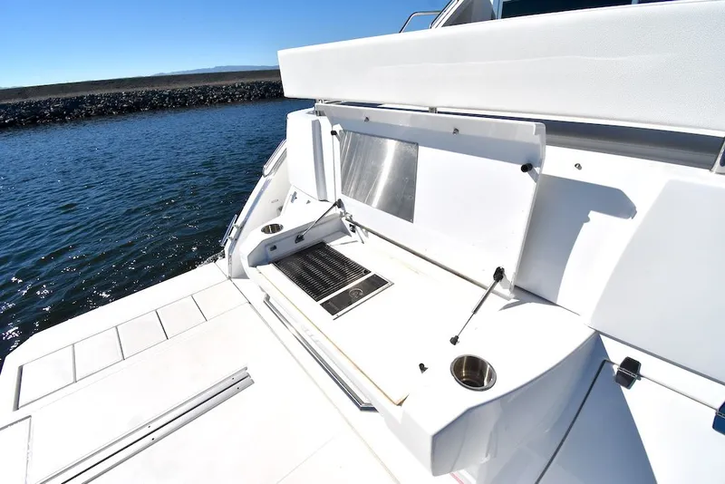 Slide: The Image of The 2019 Cruisers Yachts 50 Cantius features a spacious outdoor kitchen with a grill and sink. - 47