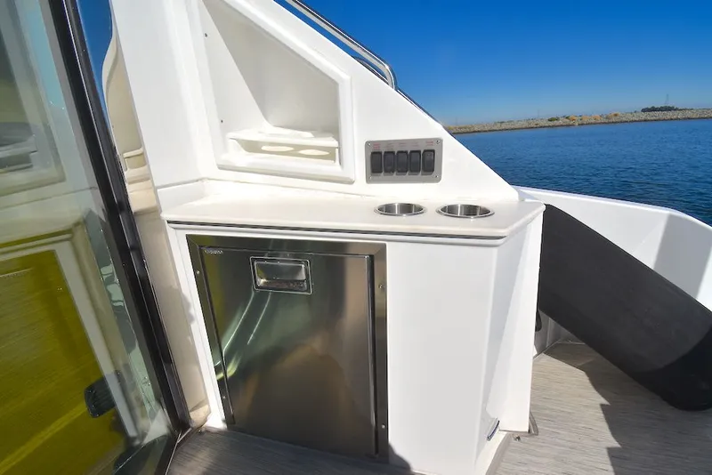 Slide: The Image of The 2019 Cruisers Yachts 50 Cantius features an outdoor kitchenette with a fridge and cup holders. - 9