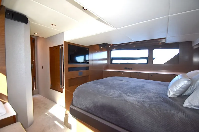Slide: The Image of Luxurious cabin with a large bed, wood furnishings, and windows in a 2019 Cruisers Yachts 50 Cantius. - 34