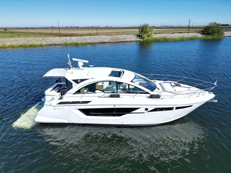 The Image of The 2019 Cruisers Yachts 50 Cantius glides on calm water, featuring an open cabin. - 0