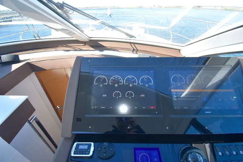 Slide: The Image of The image shows the cockpit of a 2019 Cruisers Yachts 50 Cantius with modern instruments and a view of the water. - 18