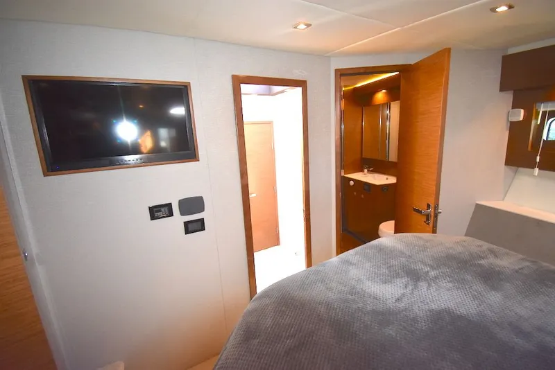 Slide: The Image of Interior of a 2019 Cruisers Yachts 50 Cantius with a bed, TV, and bathroom. - 26