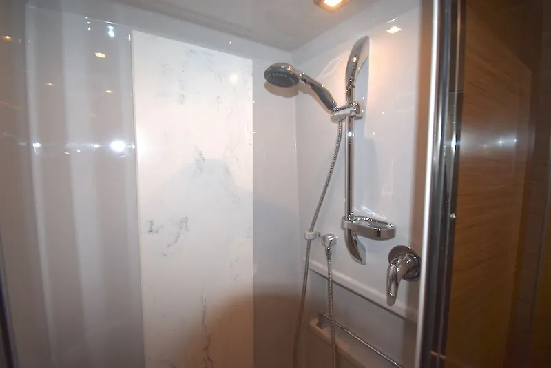 Slide: The Image of The 2019 Cruisers Yachts 50 Cantius shower features modern fixtures and a marble wall. - 28