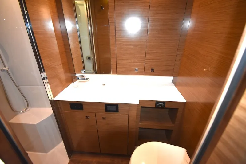 Slide: The Image of Bathroom with wood paneling, white sink, and shower in a 2019 Cruisers Yachts 50 Cantius. - 30